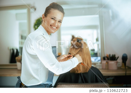 woman hairdresser in modern beauty studio with hairbrush 110622723
