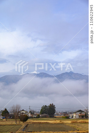 濃霧と雲の隙間から姿を見せる北アルプス【安曇野市穂高】 110622945