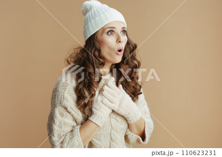 surprised modern woman in beige sweater, mittens and hat surprised modern woman in beige sweater, mittens and hat 110623231