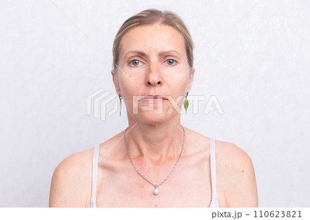 Beautiful grey-haired 50s woman looking at camera isolated on white. Beautiful grey-haired 50s woman looking at camera isolated on white. 110623821