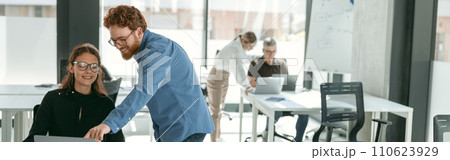 Two diverse business colleagues disscuss biz issue while use laptop in office background 110623929