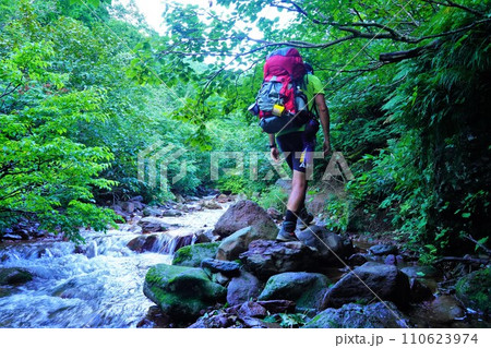 斜里岳の沢を歩く登山者 110623974