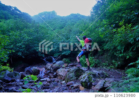 斜里岳頂上を指差す登山者 110623980