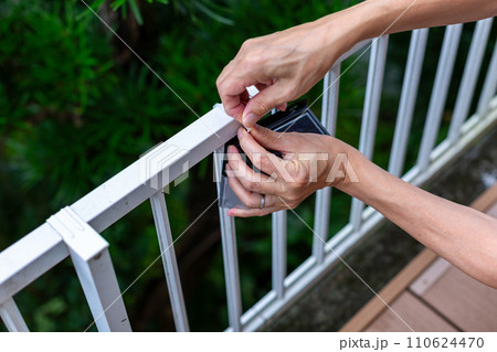 ソーラーライトを取り付ける男性 110624470