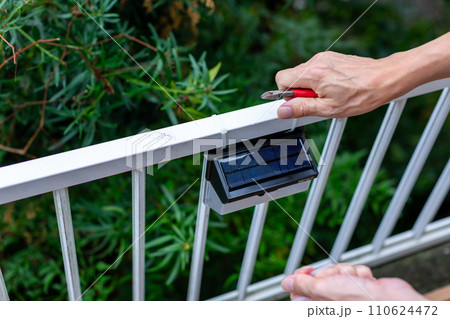 ソーラーライトを取り付ける男性 110624472