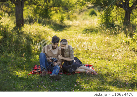 young couple looking at photos on a camera young couple looking at photos on a camera 110624476