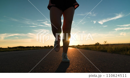 silhouette sports girl running legs along road sunset, jogging dusk, athletic woman running on trail at sunset, jogging, running silhouette, running, marathon training, summer thailand, outdoor sports 110624511