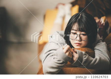 ソファーに寝転びくつろぐ女性 110624703