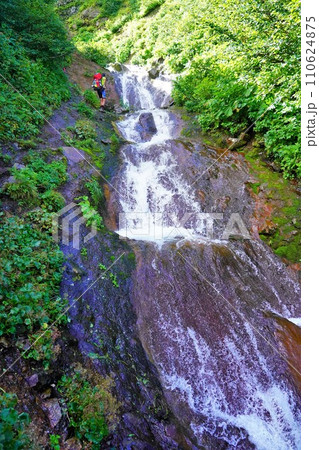 斜里岳の滝横の登山道を歩く登山者 110624875