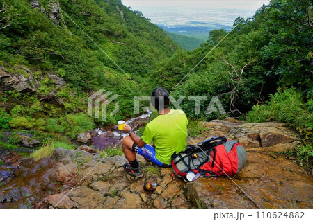 斜里岳の見晴らしの滝で休憩する登山者 110624882