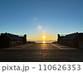 日の出に照らされる道 110626353