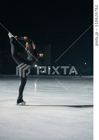 Beautiful young woman ice skating and performing short program 110626762