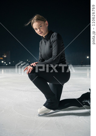 Beautiful young woman ice skating and performing short program Beautiful young woman ice skating and performing short program 110626769