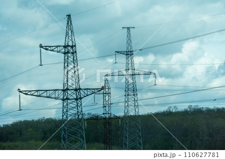 High voltage towers with sky background. Power line support with wires for electricity transmission. High voltage grid tower with wire cable at distribution station. Energy industry, energy saving 110627781