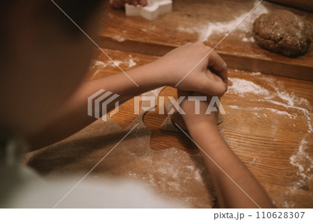 Process of making heart-shaped gingerbread for Christmas and New Year. Traditional festive food making, family culinary.  110628307