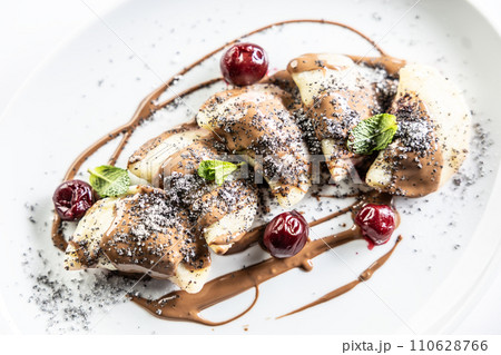 Eastern European traditional food dumplings - pierogi, varenyky, pirohy filled with strawberries and topped with chocolate. Isolated on white Eastern European traditional food dumplings - pierogi, varenyky, pirohy filled with strawberries and topped with chocolate. Isolated on white 110628766