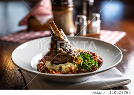 Confit lamb calf on mashed potatoes and baking sauce. Roasted leg of mutton with potatoes on a plate in a restaurant 110628769
