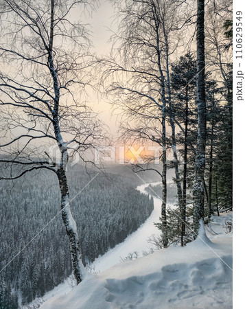 Beautiful sunrise on a frosty morning, a snowy cliff, trees on the edge. Beautiful sunrise on a frosty morning, a snowy cliff, trees on the edge. 110629549