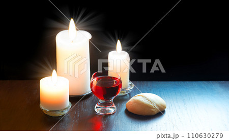 A bowl of wine and bread on the table. Communion symbols 110630279