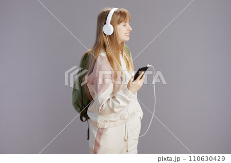 happy teen girl listening to music and using phone happy teen girl listening to music and using phone 110630429