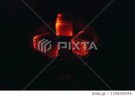 smoking hookah in the evening, smoldering coals of the hookah bar. smoking hookah in the evening, smoldering coals of the hookah bar. 110630444