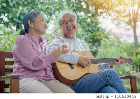 Happy two Asian senior couple elderly man playing the guitar while his wife is singing together at home outdoors, Enjoying lifestyle during retirement life having fun, Activity family health care Happy two Asian senior couple elderly man playing the guitar while his wife is singing together at home outdoors, Enjoying lifestyle during retirement life having fun, Activity family health care 110630458