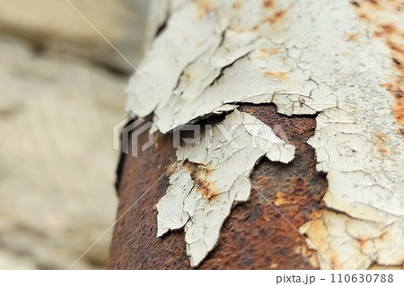Peeling old paint from a metal pipe that has corroded. Chemical transformations in building materials that lead to destruction 110630788