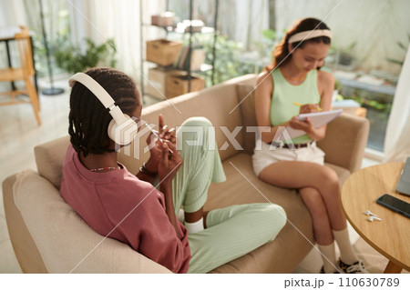 Girl listening to music and filing nails when her friend preparing for exam 110630789