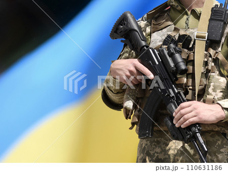 Soldier with assault rifle and flag of Ukraine. Ukrainian soldier with assault rifle AK. 110631186