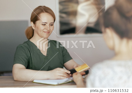 happy therapist woman in massage cabinet accepting payment happy therapist woman in massage cabinet accepting payment 110631532