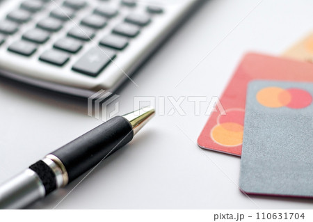 Close-up of pen, credit cards and calculator Close-up of pen, credit cards and calculator 110631704