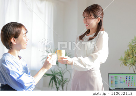 コーヒーカップで乾杯するデザイナー女性2人_1 コーヒーカップで乾杯するデザイナー女性2人_1 110632112