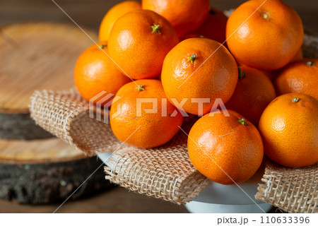 mandarin fruits on a white stone cakes stand. 110633396