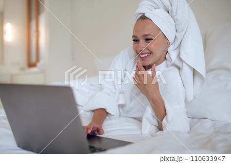 Young woman chatting online and looking contented 110633947