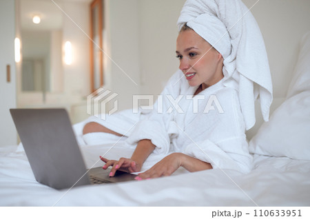 Young woman chatting online and looking contented 110633951