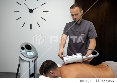 Male therapist working with a patient in a rehabilitation clinic 110634033