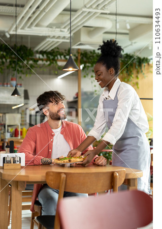 African american waitress taking order from customer in a cafe 110634493