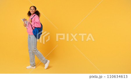 African girl student holds workbooks posing with backpack, yellow background African girl student holds workbooks posing with backpack, yellow background 110634613