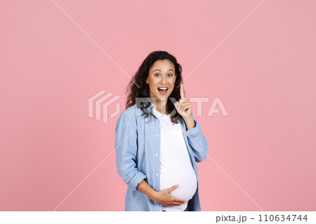 Excited pregnant woman with big belly raising finger up, eureka 110634744