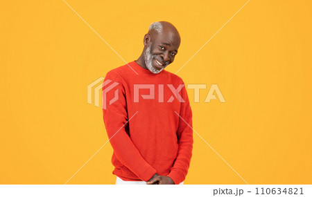 Smiling confident senior man in a red sweater and hat standing with hands in pockets Smiling confident senior man in a red sweater and hat standing with hands in pockets 110634821