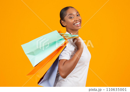 Portrait of happy black woman posing with shopper bags packages 110635001