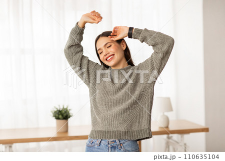 Carefree young woman dancing alone at home Carefree young woman dancing alone at home 110635104