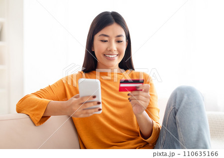 Attractive young asian woman with credit card and smartphone Attractive young asian woman with credit card and smartphone 110635166