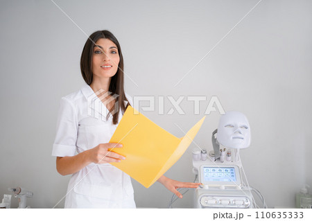 Smiling woman cosmetologist with medical report in Smiling woman cosmetologist with medical report in 110635333