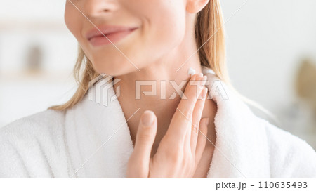 Cropped of lady pampering neck skin with moisturizer in bathroom 110635493
