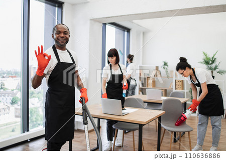 African American man using vacuum cleaner to clean floor from dirt. African American man using vacuum cleaner to clean floor from dirt. 110636886