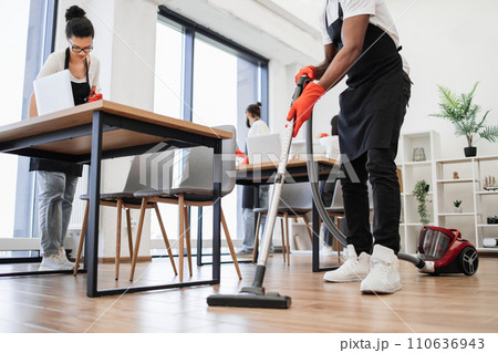 Cropped view of hands of African man holding vacuum cleaner. 110636943