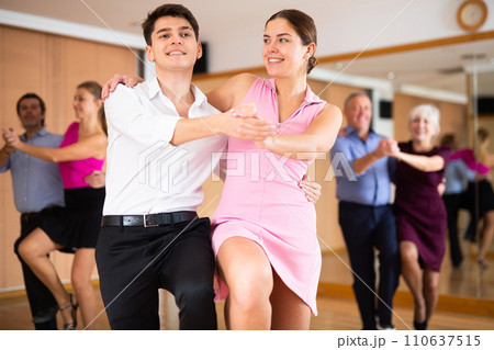 Young pair practicing Latino dance in dance studio Young pair practicing Latino dance in dance studio 110637515
