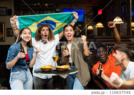 Enthusiastic group of sports fans celebrating victory of favorite Brazilian team in bar 110637548