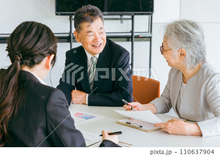 提案された書類を確認する高齢者夫婦（資産運用・投資・金融商品） 110637904
